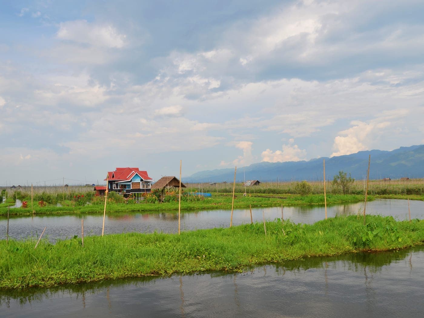 A timber house raised on stilts above calm water.